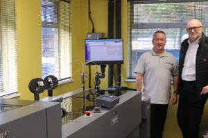 Paul Dale Production Director at Image Evolution (Left) in front of the machine along with Lyle Rainey (Right) Regional Sales Manager for Duplo