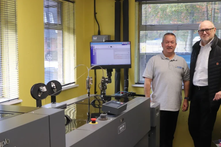 Paul Dale Production Director at Image Evolution (Left) in front of the machine along with Lyle Rainey (Right) Regional Sales Manager for Duplo